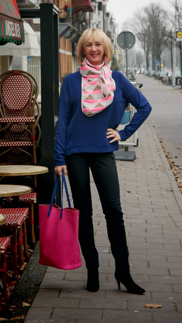 A blue sweater as a background for a pink scarf