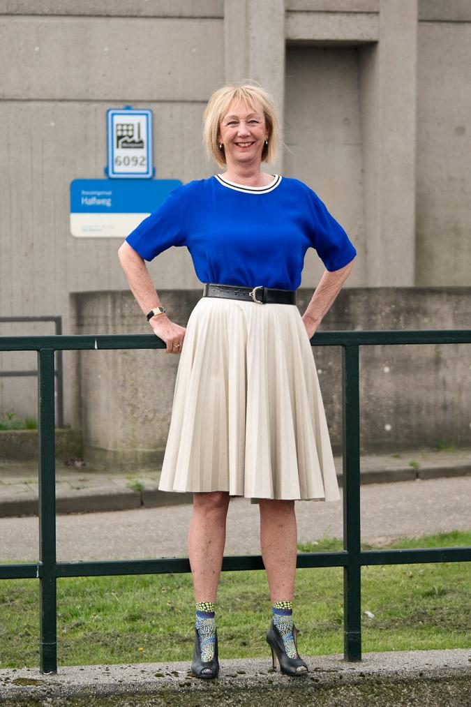 Bright blue top with a camel pleated skirt
