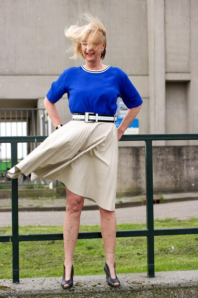 Bright blue top with a camel pleated skirt