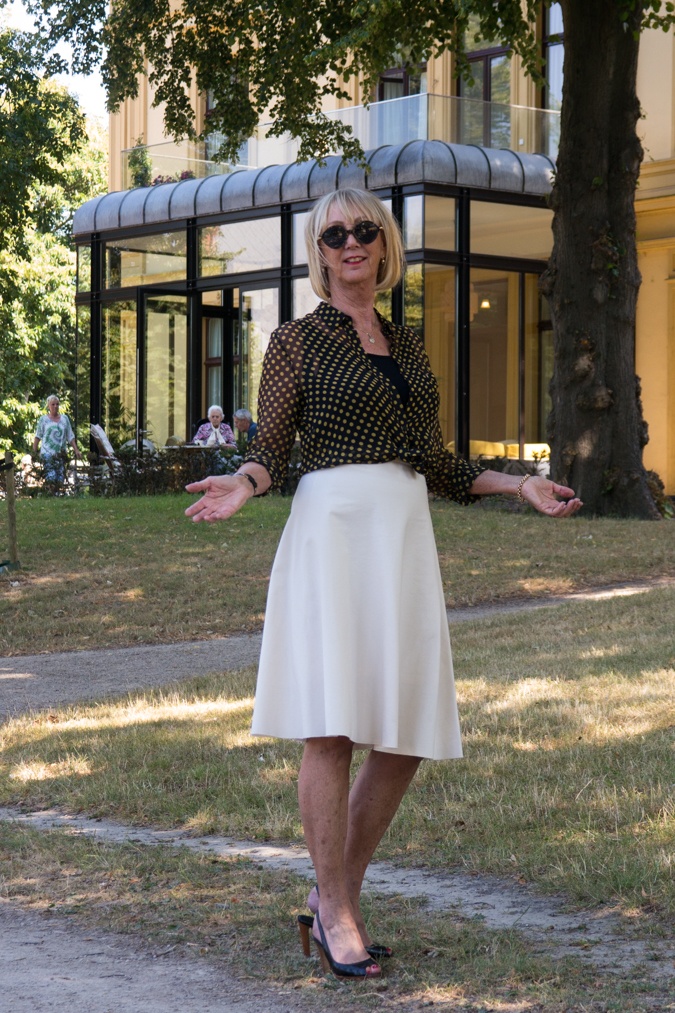 Wide cream skirt with black and yellow polka dot blouse