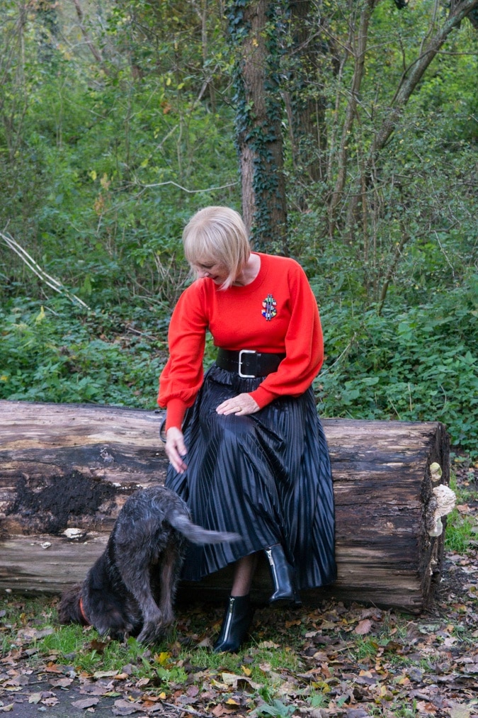 Red jumper on black pleated skirt