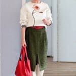 A green midi skirt with a cream sweater
