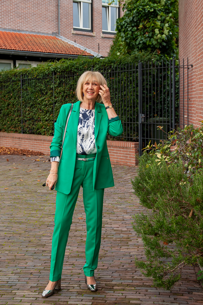 Green suit with blue, silver, white blouse and silver pumps