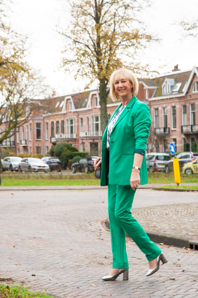Green suit with blue, silver, white blouse and silver pumps