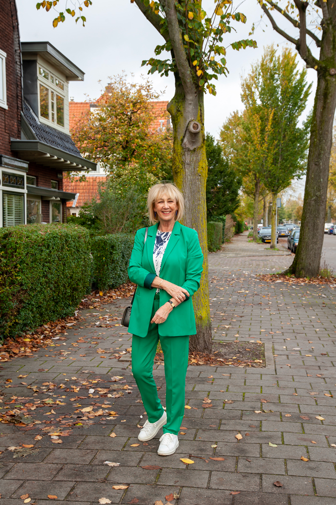 Green suit with blue, silver, white blouse and white trainers