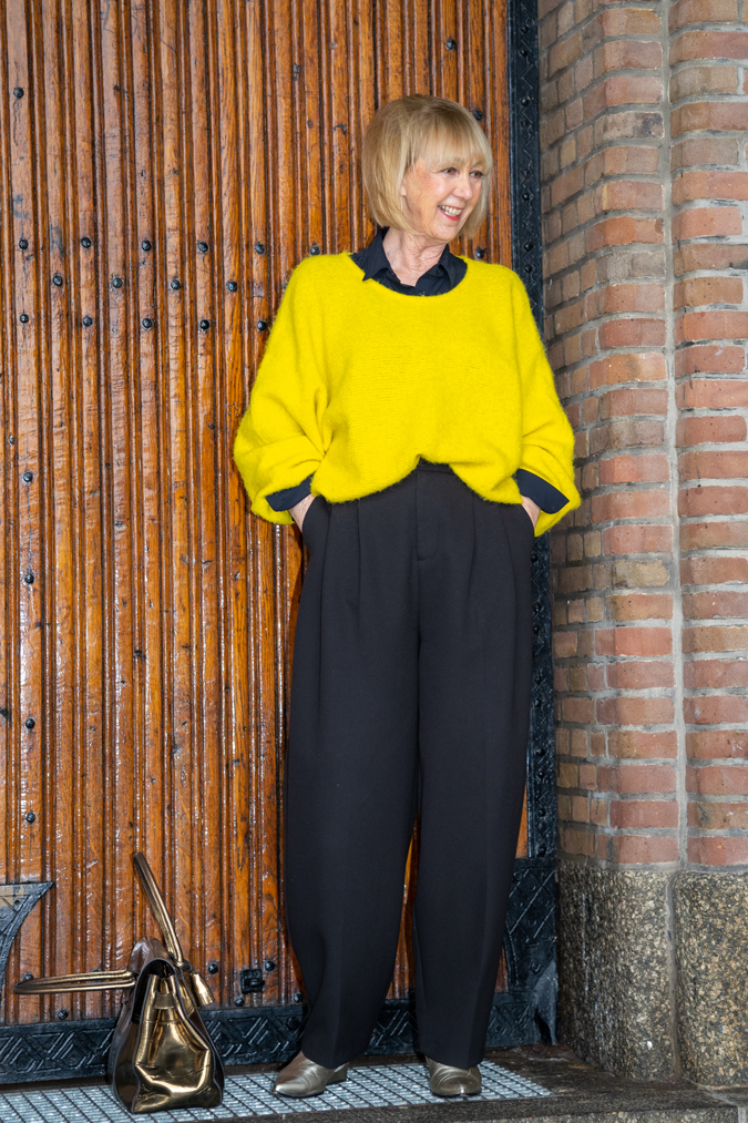 Wide black trousers and a big yellow jumper