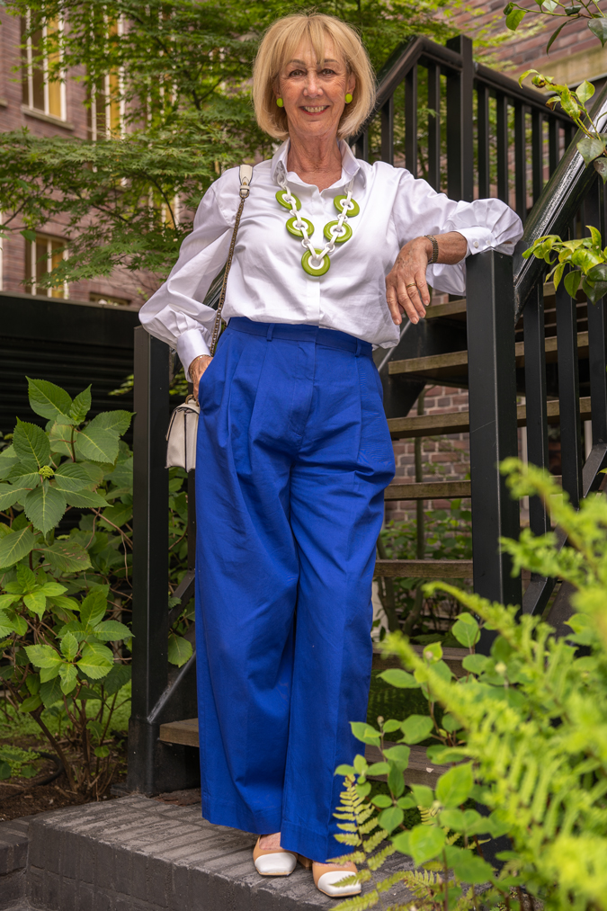 Cobalt blue trousers with green and white necklace by Angela Caputi