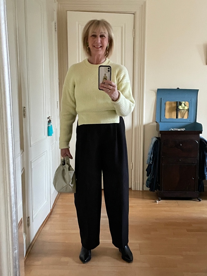 Outfit with wide black trousers and a soft yellow jumper
