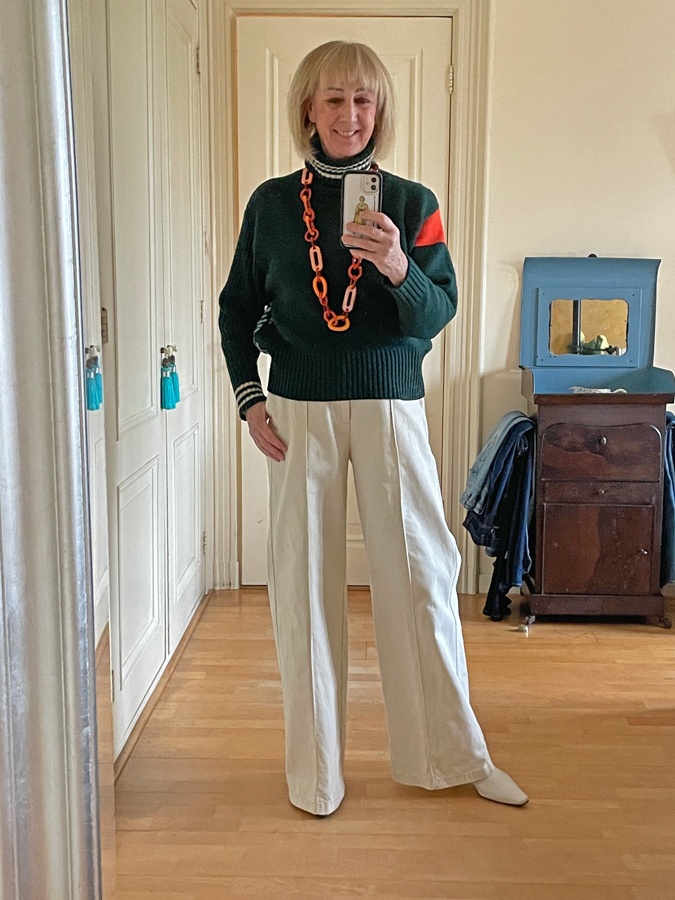 Green jumper with wide cream trousers