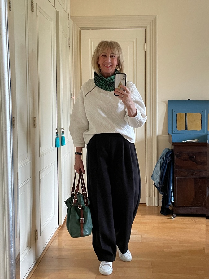 Wide black trousers with white sweater