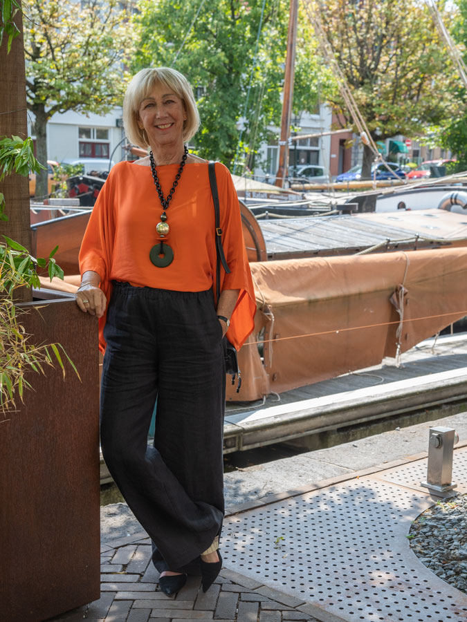 Black linen trousers with an orange top