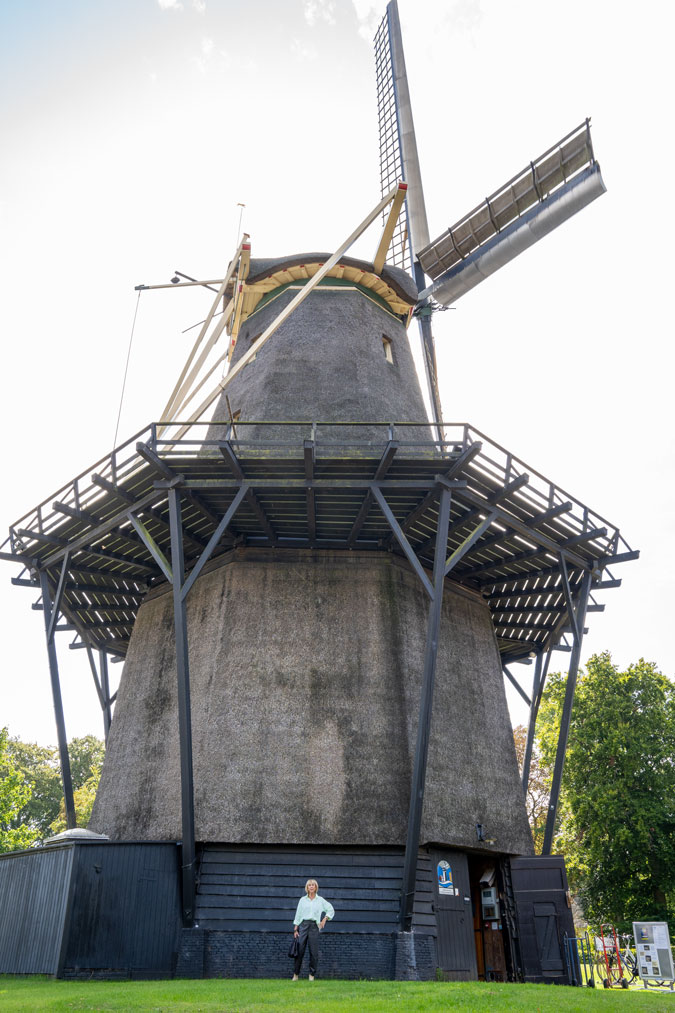 Brown vegan leather trousers in front of a mill