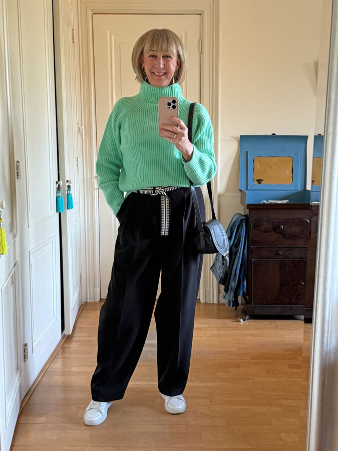 Bright green jumper with wide black trousers