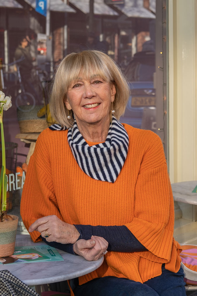 Close-up orange jumper and pendant earrings