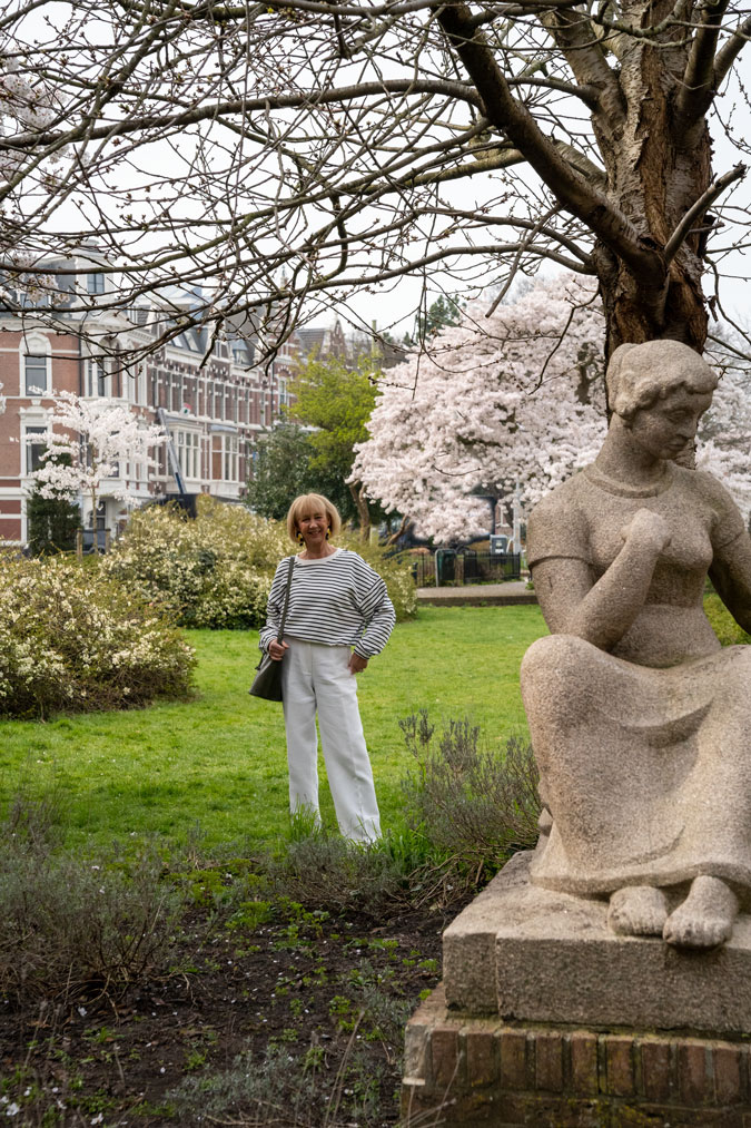 Blue and white striped sweater with white trousers