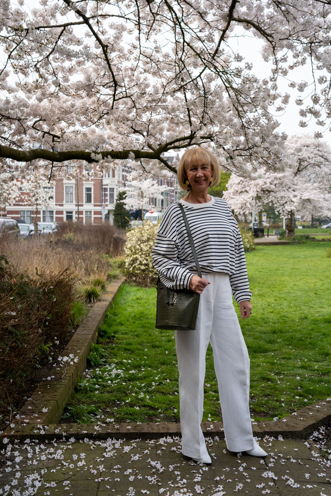 Blue and white striped sweater with white trousers