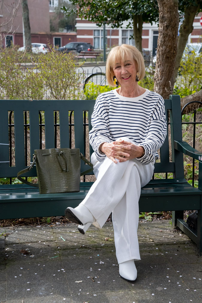 Blue and white striped sweater with white trousers