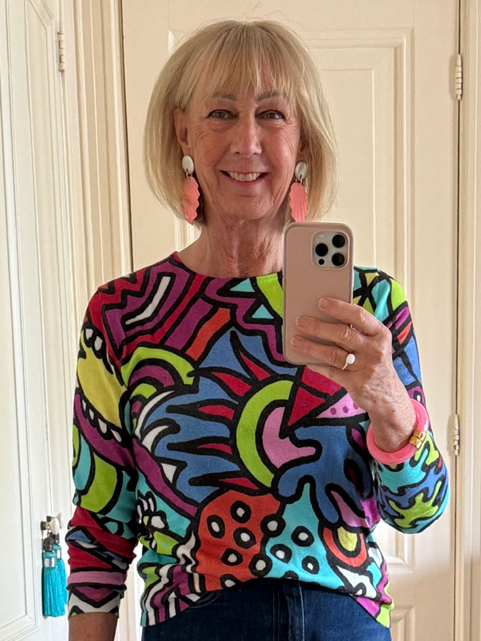 colourful jumper with pink earrings