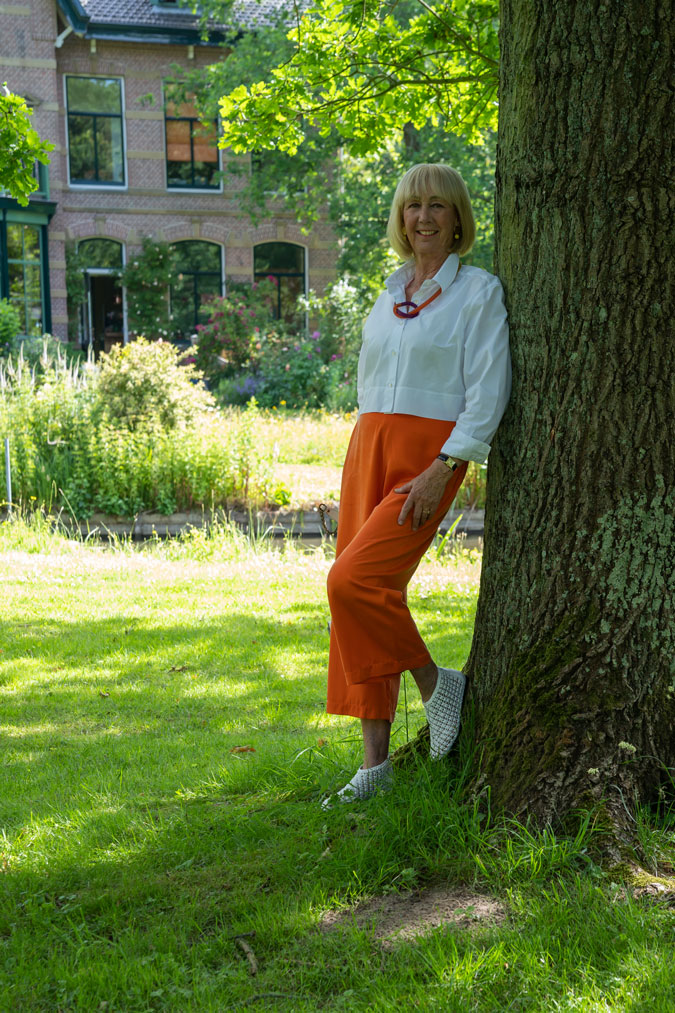 White cropped blouse jacket with orange trousers