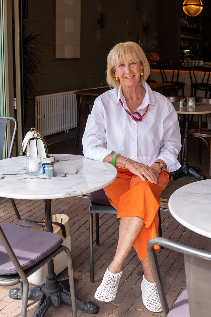 White cropped blouse jacket with orange trousers