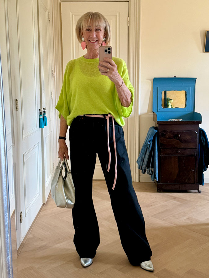 Black jeans with a lime green cashmere jumper